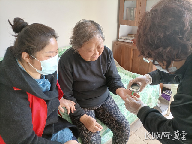 社区工作者上门为老奶奶测血糖。白月 供图