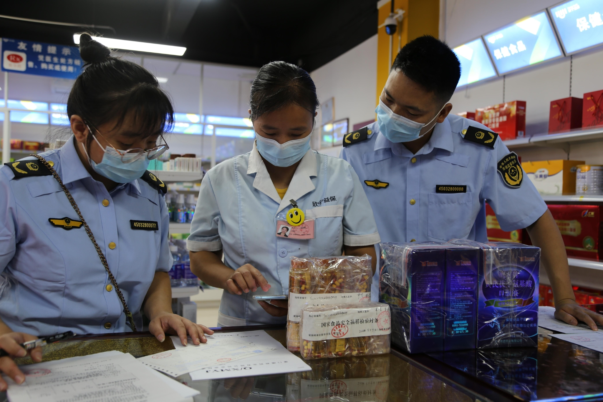 龙胜县市场监管局抽检人员在和药店销售人员核对抽检样品。兰晓孟/摄