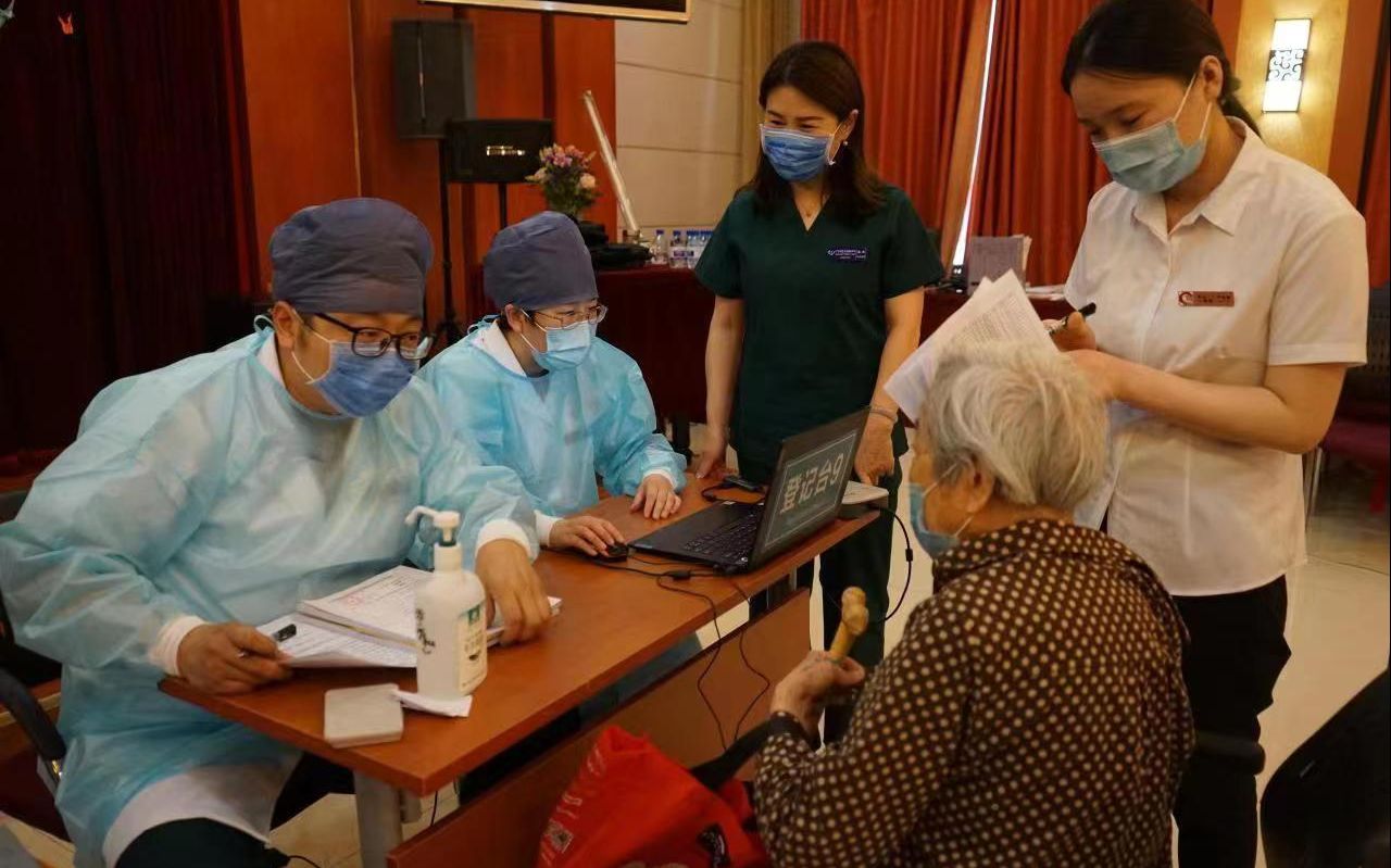 在广宁街道寿山福海养老院，狄安强和“轻骑队”同事们为老年人做新冠疫苗接种前的信息登记。受访者供图
