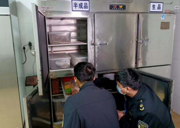 乐昌市市场监管局执法人员检查冰箱食品储存情况。