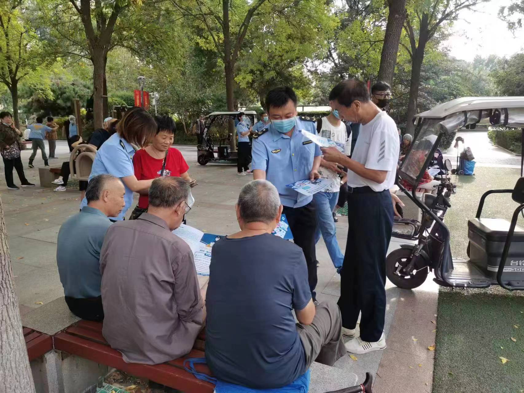 市场监管人员发放防诈骗宣传资料。尹训银/摄