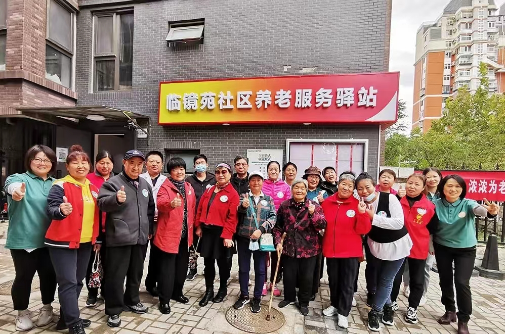 临镜苑社区养老服务驿站工作人员与老人们合影。门头沟区委宣传部供图