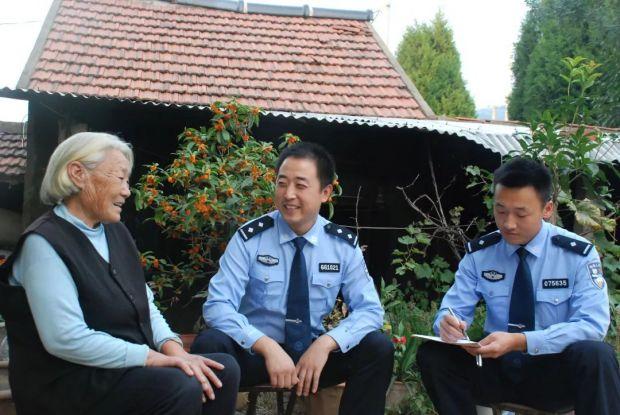 图为民警走村入户宣传反诈知识。