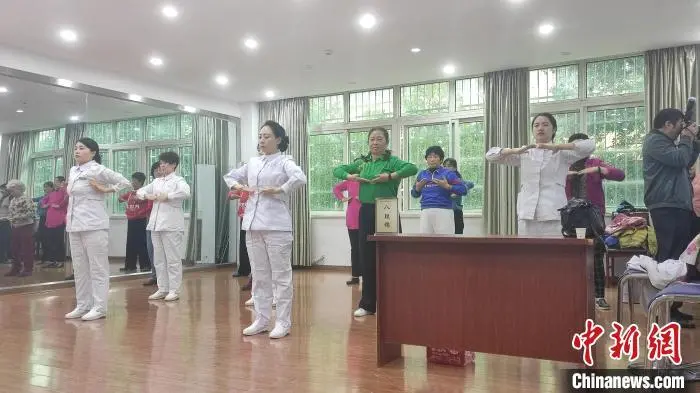 图为景德镇市珠山区昌河街道昌盛社区内，景德镇市中医医院医护人员正带着社区老年人做八段锦。巫发阳 摄