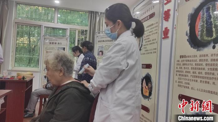 图为景德镇市珠山区昌河街道昌盛社区内，景德镇市中医医院医护人员正在给社区老年人做热敏灸。巫发阳 摄